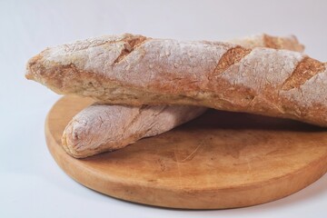 fresh cut baguettes on the wodden tray with butter. sourdough baguettes. healthy food.
