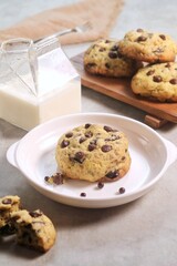 Soft Chocochip Cookies on white plate, served with milk.
