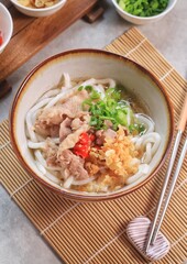 Japanese traditional noodle soup Niku Udon with kakedashi soup, fish stock soup and then topped with sliced beef and sliced scallions.
