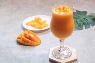 Fresh beautiful delicious mango juice. Close up design concept of smoothie cold drink in glass cup. 
