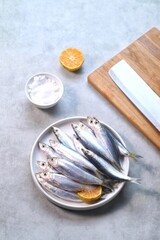 Fresh sardines, lemon and salt on kitchen, landscape shot.