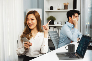 Profile smiling beautiful Asian businesswoman looking camera, using phone for advertisement at...