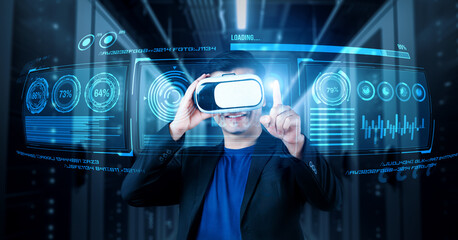Businessman with headset standing at data center while analyzing financial data. Manager pointing marketing statistic hologram and using augmented reality goggles while making a decision. Ingenuity.