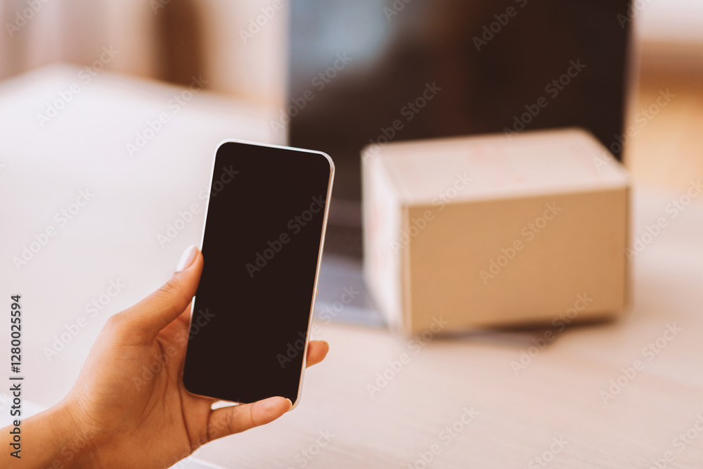 Aufkleber Gadget Mockup For Website Or App. Unrecognizable black lady holding mobile phone in hand, showing device with empty screen for template. Laptop with cardboard box on keyboard in blurred background
