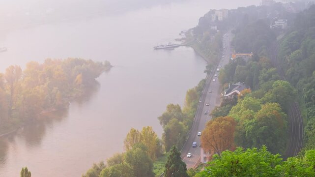 Misty dawn morning aerial view in the autumn with tree leaves changing color above the Rhine River, Germany