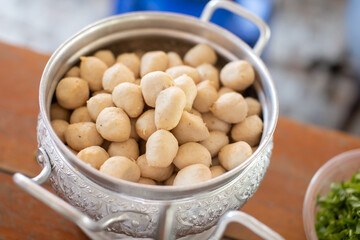 Pork meatballs are placed in a silver container.