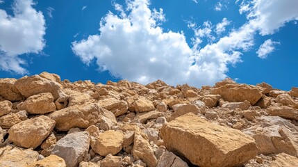 Tan and Beige Rocks Against a Vivid Blue Sky with Puffy Clouds