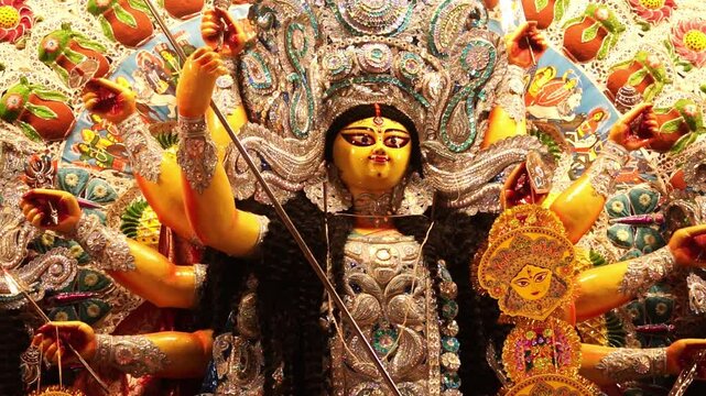 statue of goddess durga adorned with intricate jewellery with ten hands holding weapons