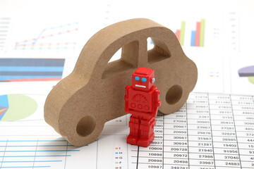 Business concept with miniature robot, car model, and financial graphs