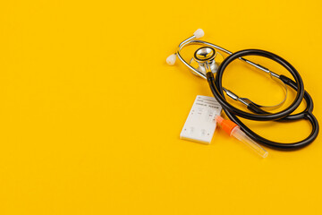 Stethoscope and supplies on bright yellow for health awareness