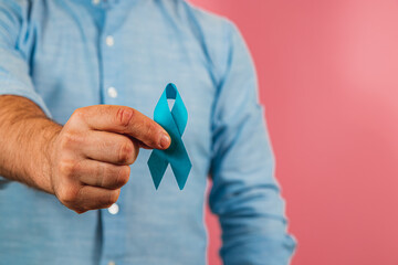 Support for cancer awareness with a blue ribbon in hand