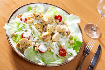 Delicious fresh caesar salad with parmesan and sliced chicken served on plate
