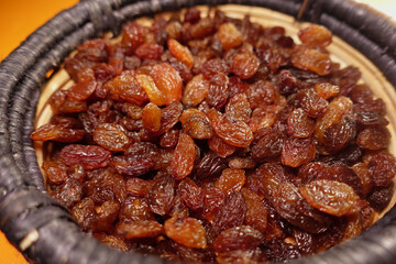 Freshly harvested dark raisins in a wicker basket ready for use