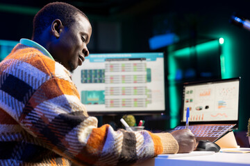 Self employed investment expert working from home, analyzing financial statistics to develop a global investment solution for growth. Economy advisor examines declared revenue balance.