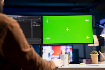 Man does software quality assurance, reading source code on mockup green screen computer before...