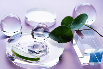 Aloe and centella serum droplets on glass with stones and leaves in a serene spa setting.