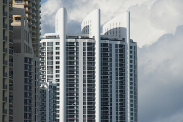 Obraz premium Miami. Skyscraper with reflective windows, cloudy sky. Tall building, curtain wall facade, common modern skyscraper design. City view with clouds.