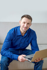 Fototapeta premium Young man working at computer from home in bright cozy room, education and business