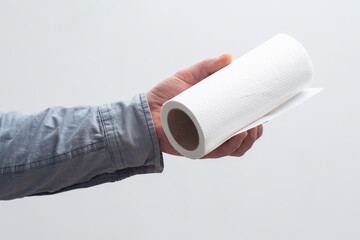 Clean white paper towel roll held by hand, for household use.