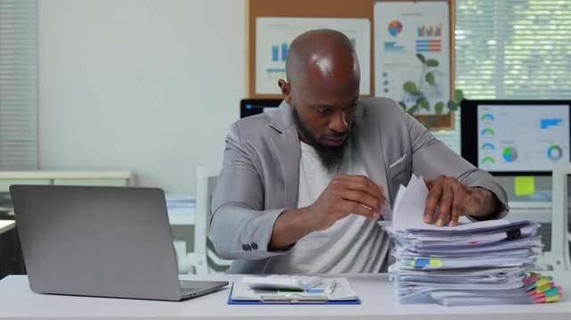 Concentrated office manager meticulously reviewing substantial stack of documents, displaying professional work ethic and analytical precision at corporate workspace