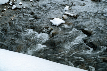 Snow-Covered River Flowing Through Winter Forest in hokkaido japan