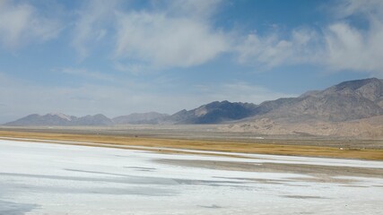 Desert landscape with salt flat and mountains.