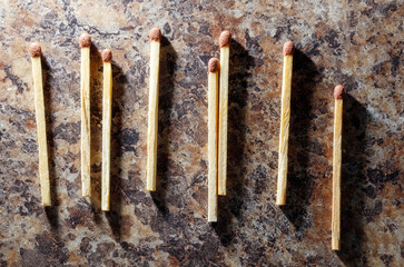 A row of matches with a small piece of wood on top of them