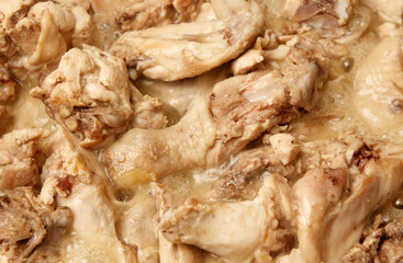 A close up of chicken pieces in a pan with a sauce