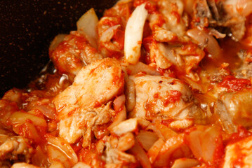 A pot of food with meat and onions in it
