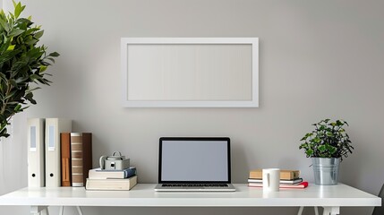 A white rectangular frame above a desk in a home office, surrounded by a laptop, books, and a coffee mug.   HD 8K mockup wallpaper Photographic Image