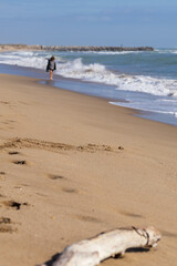 A peaceful day at the beach. Distant figure walking the shoreline, the ocean waves, soft sand....
