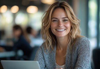Fototapeta premium Bright smile of a woman working on a laptop in a modern café during the day while surrounded by blurred backgrounds of other people