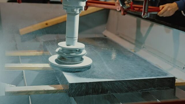 Head of machine grinding stone slab, water splashes to. Grinding porcelain tiles with special nozzle. Manufacture of monuments and polished granite, stone industry