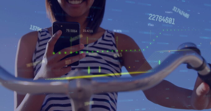 Image of graph and processing data over caucasian woman on bike using smartphone