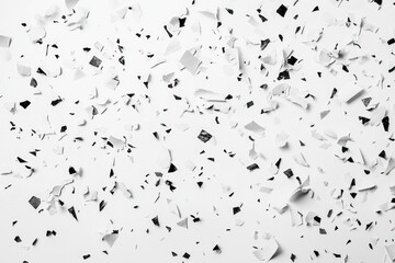 Obraz premium White and black confetti scattered on white background.