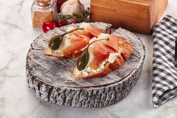 Bruschetta with jamon and caper berries