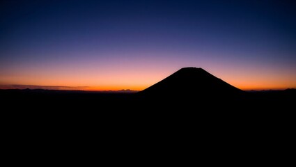 Dramatic Volcano Silhouette at Dusk Over a Vast Plain