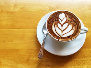 Cup of coffee  with Latte Art servedon wooden table.