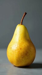 Luscious ripe pear, golden hue, gray backdrop, culinary, fresh, single