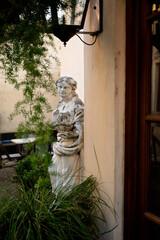 Weathered stone statue in a charming courtyard with greenery