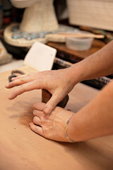 Artisan's hands kneading clay in a pottery studio workspace