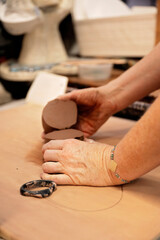 Artisan slicing clay pieces in a pottery studio workspace