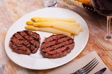 Pork cutlets with baked white asparagus on plate