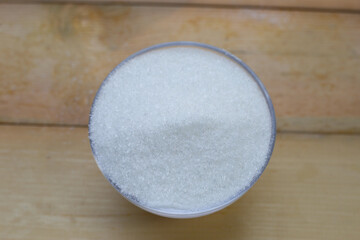 Monosodium glutamate in bowl on wooden background.
