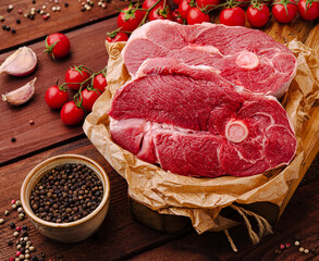 Fresh cuts of meat neatly arranged with cherry tomatoes and spices