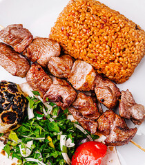 Turkish kebab platter with bulgur and fresh vegetables served warm
