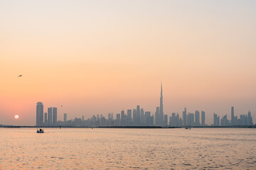 Naklejka premium Dubai skyline emerging from the haze at sunrise with burj khalifa tower