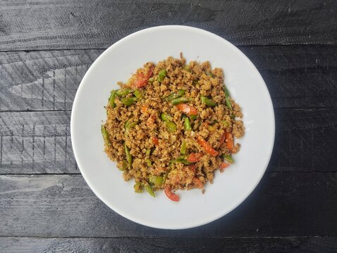 Oseng-oseng oncom or Stir-fried fermented soybeans on plate, Flat lay. Indonesian typical food 