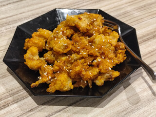 Crispy broccoli with chili sauce served on a black plate. Crispy broccoli with chili sauce served on a black plate, served in a cafe.