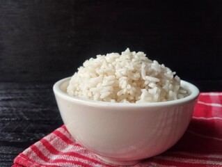 Nasi putih or white rice in bowl with black wooden table background 